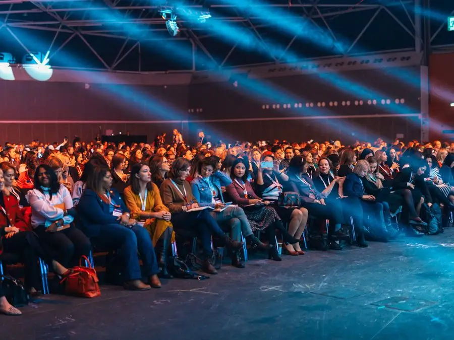 Plateia de um congresso em auditório diante do palco iluminado