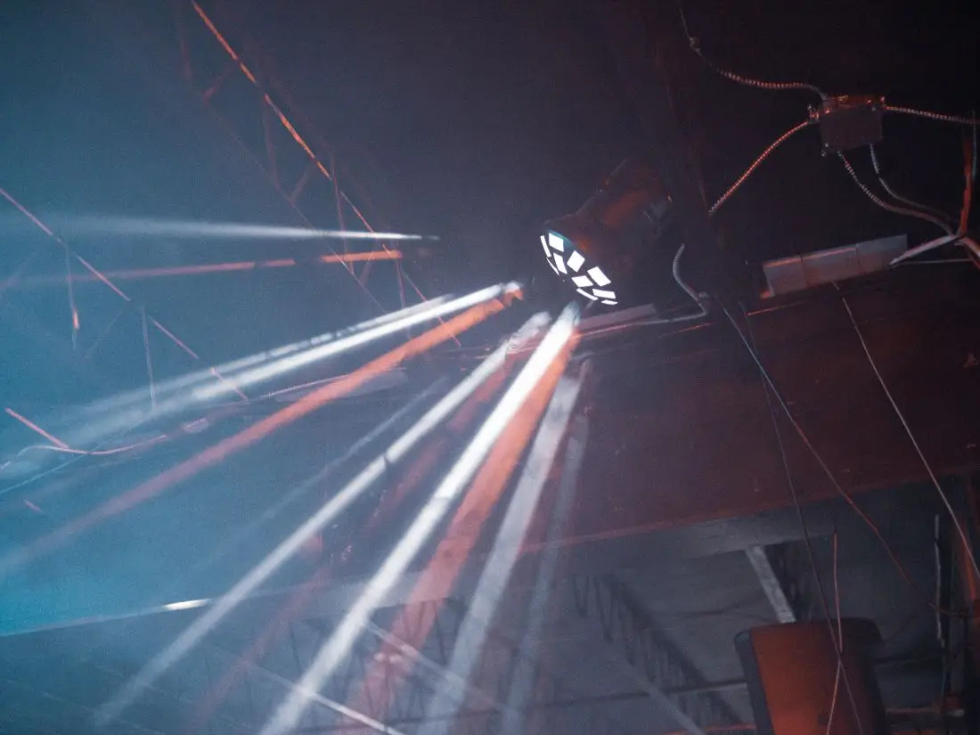 Feixes de luz cênica cortando a fumaça em um palco escuro