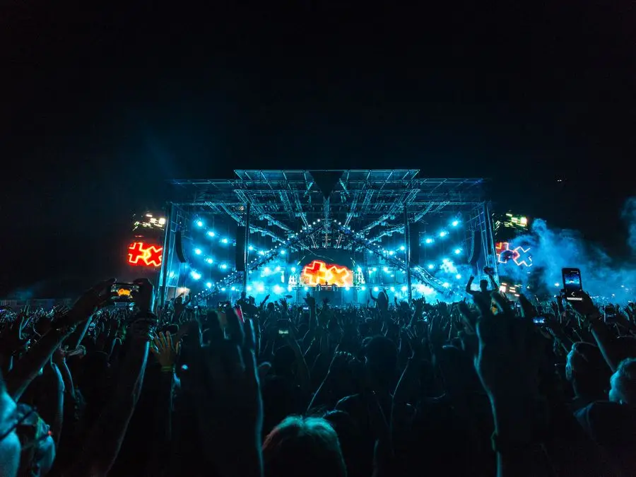 Público diante de um palco iluminado durante um show